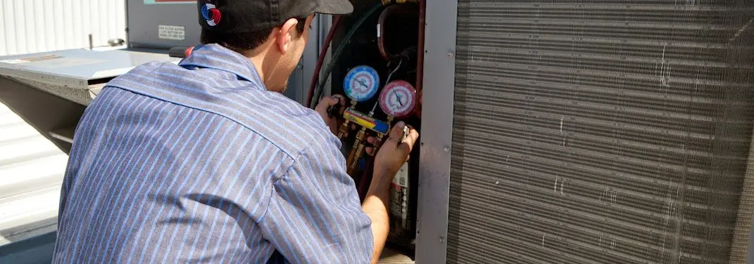 HVAC technician servicing a condenser unit in Lanham